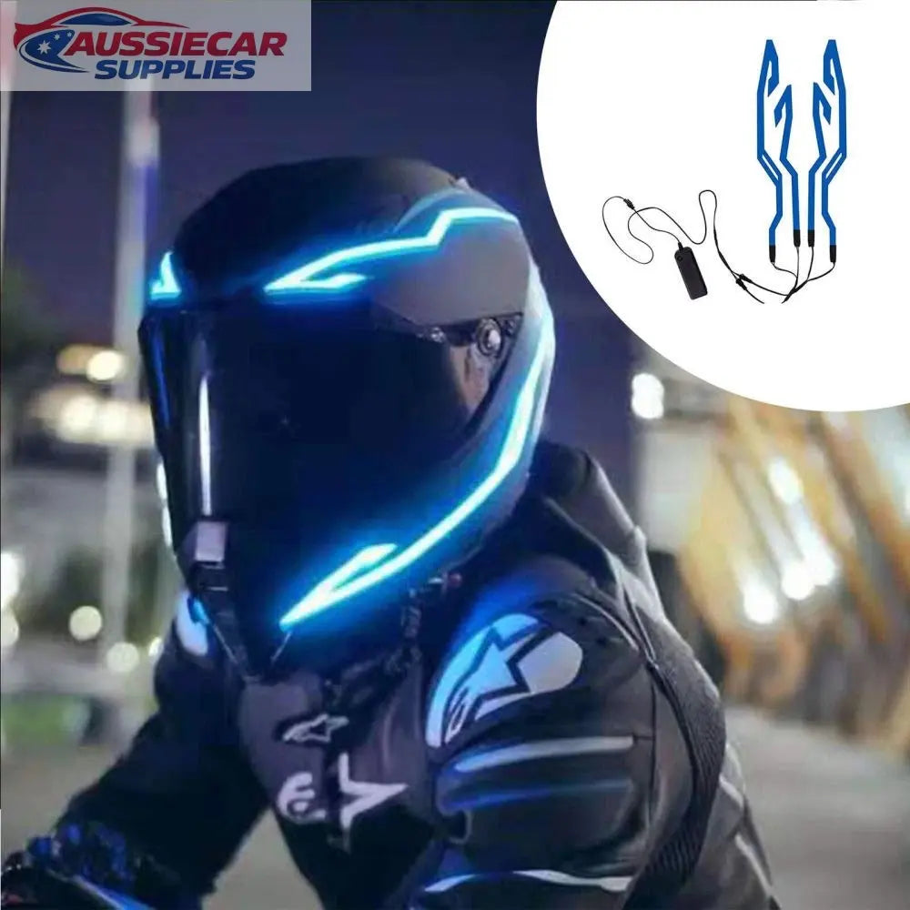 Person wearing a futuristic motorcycle helmet with blue lights at night.