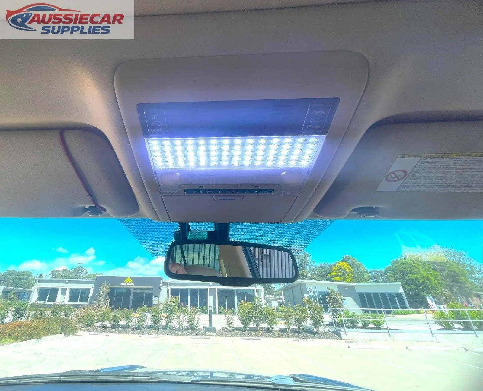 Car interior with a sun visor light and rearview mirror, showing a ...